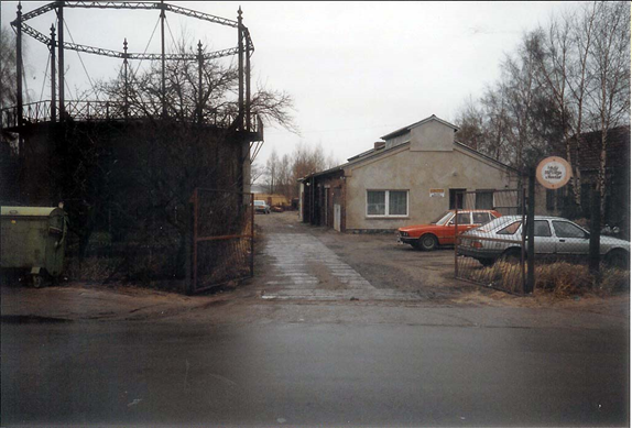 Bild zeigt das Betriebsgelände 1991 mit Gasometer und altem Gebäude.