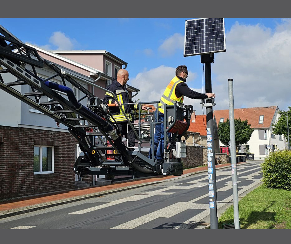 Bild zeigt Feuerwehr auf Hebebühne, die das Solarfeld einer Geschwindikeitsanzeige demontieren, in der Straße "Am See" in Ribnitz.